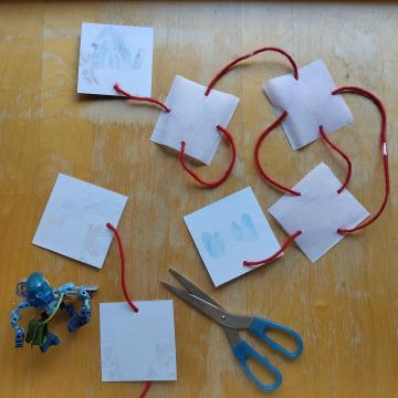 A pair of scissors showing the string being cut directly at entrance, disconnecting it from the rest of the squares.