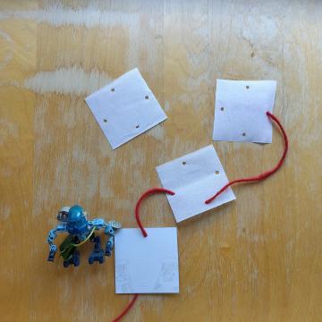 The red string is beginning to snake it’s way through all the holes of the white squares.