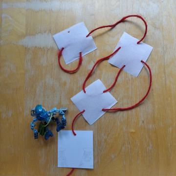 The red string has no gone through all except one of the holes on the white squares.