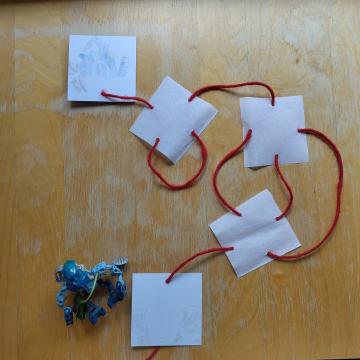 Red string connecting the last hole to a drawing of Kantai’s hut.